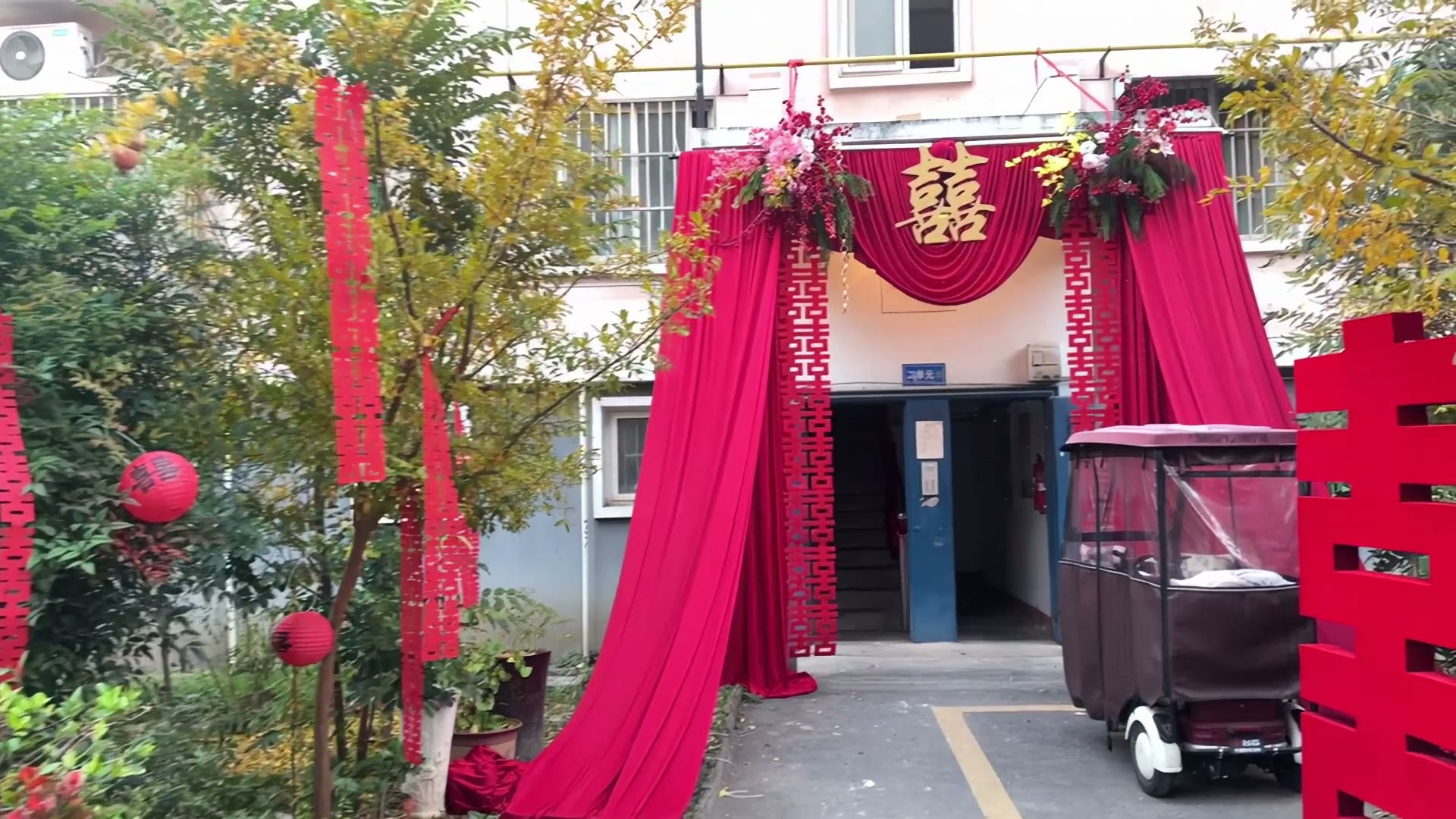 红色布幔喜字小区婚房布置